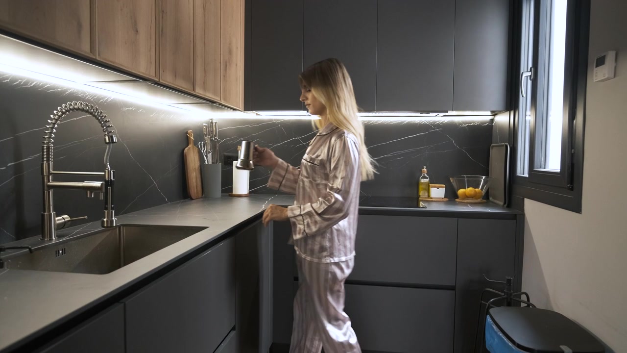 Giovane donna che prepara il caffè in una cucina moderna