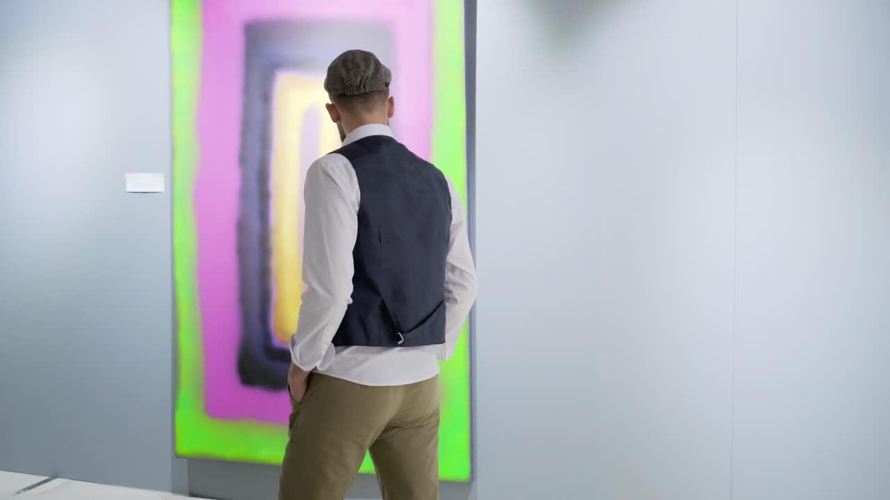 갤러리에서 추상 예술을 보는 남자