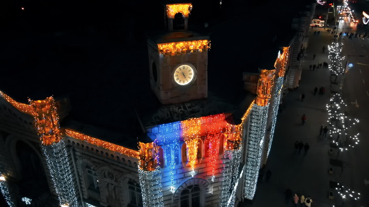 Vista aerea notturna di Chișinău addobbata per Natale, Moldova. Centro città, municipio, illuminazione, strada con auto, persone a passeggio