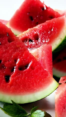 freshly sliced watermelon with mint leaves on a white background