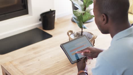 a young african american man examines smart home app energy usage on a tablet