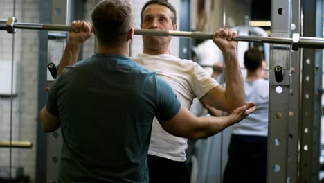 man lifting empty barbell in gym