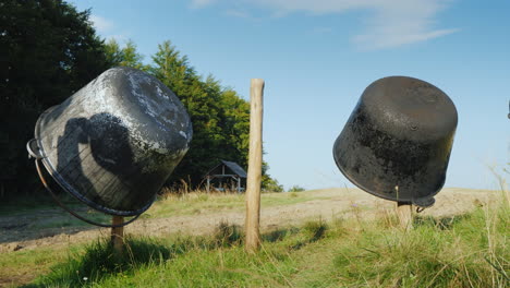 several iron vats for making cheese are dried on the fence a small cheese factory in the mountains