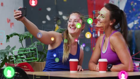 animación de iconos de los medios sobre dos mujeres caucásicas que se toman una selfie en la pared de escalada