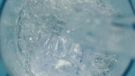 agua en cascada sobre cubos de hielo causando una salpicadura refrescante