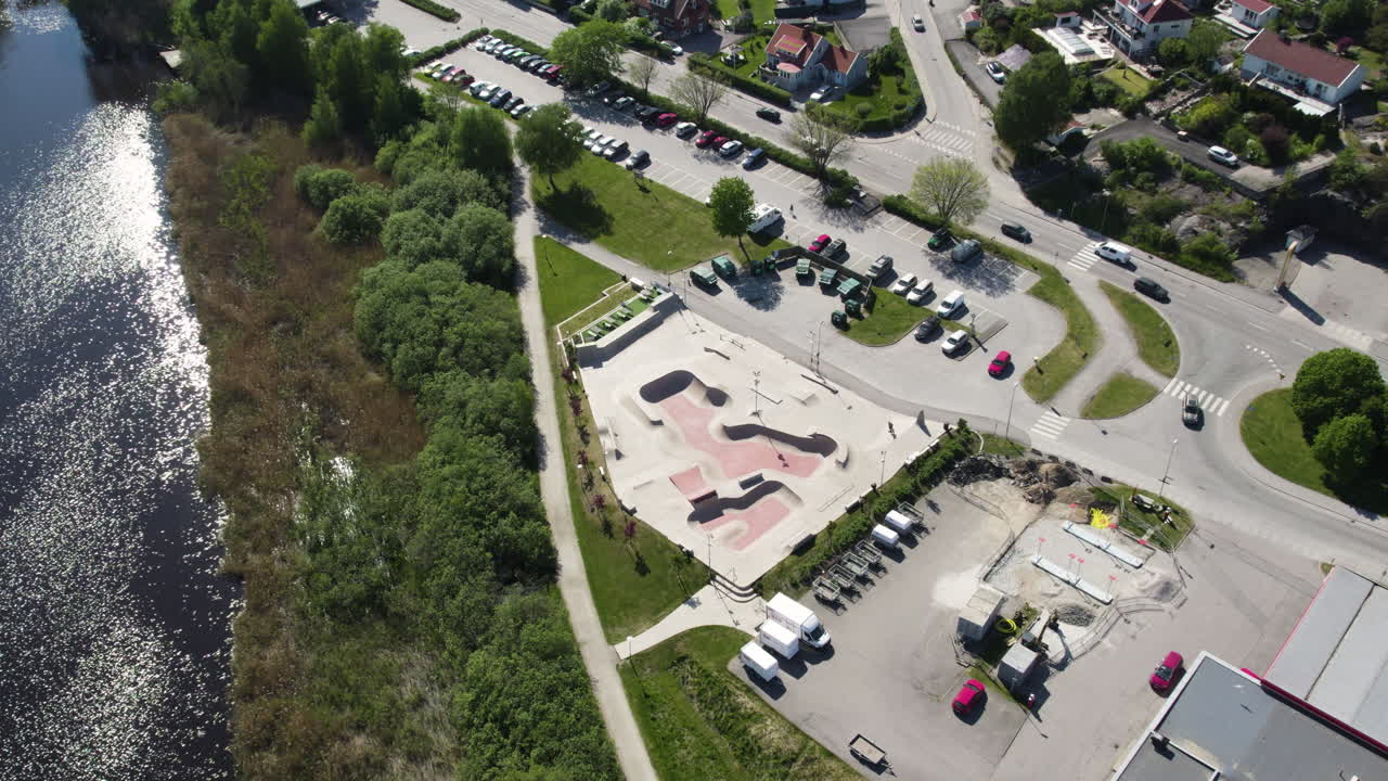 Aerial View of a Skatepark Next to a River, Surrounded by Roads and Buildings