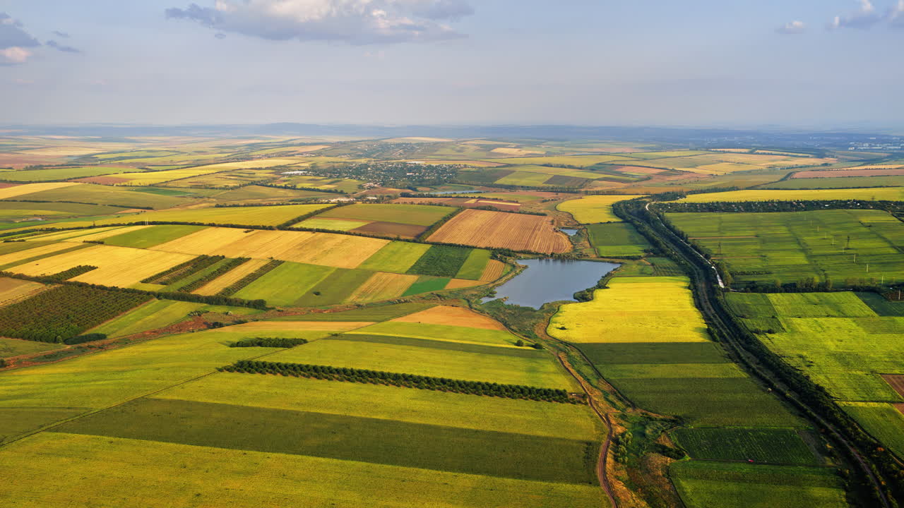 Aerial drone view of a quiet Moldovan countryside with a winding river dividing green and yellow fields