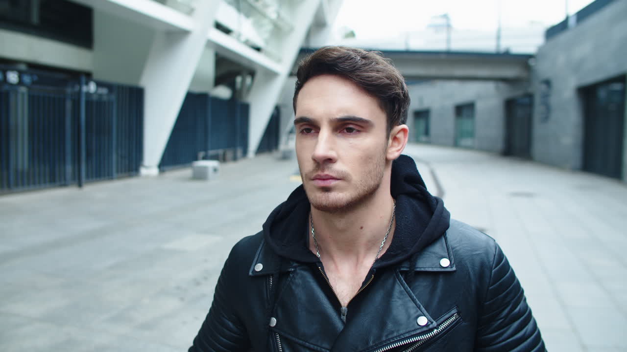 길거리를  ⁇ 는 젊은 남자의 클로즈업. 도시 거리를 가는 웃는 남자의 초상화