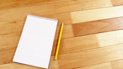 bloc de notas y lápiz en una tabla de madera