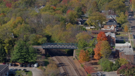 Vías-Férreas-Y-Puente-En-Kirkwood,-Missouri-En-Un-Hermoso-Día-De-Otoño-Con-Una-Inclinación-Hacia-Abajo-Para-Revelar-La-Estación-De-Tren