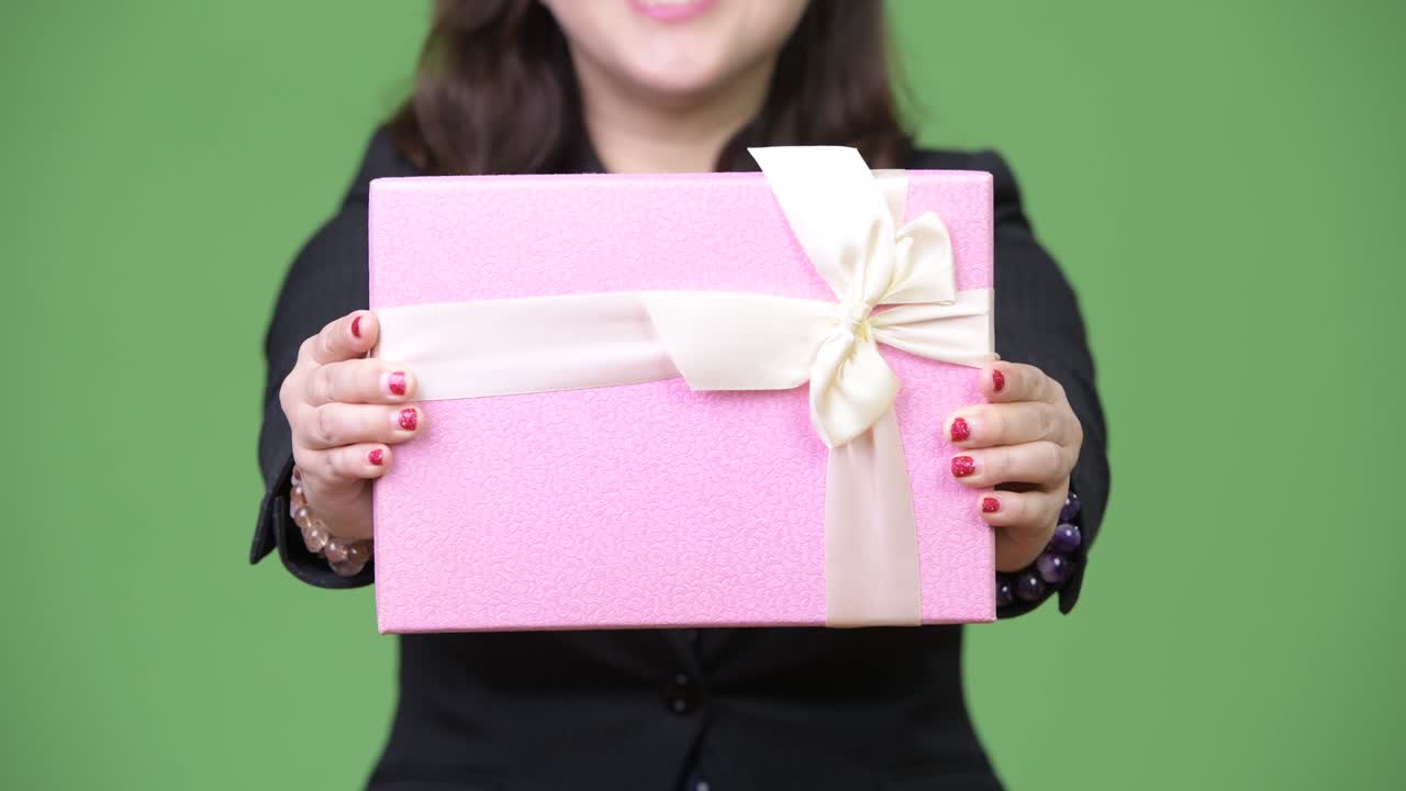 Mature beautiful Asian businesswoman giving gift box