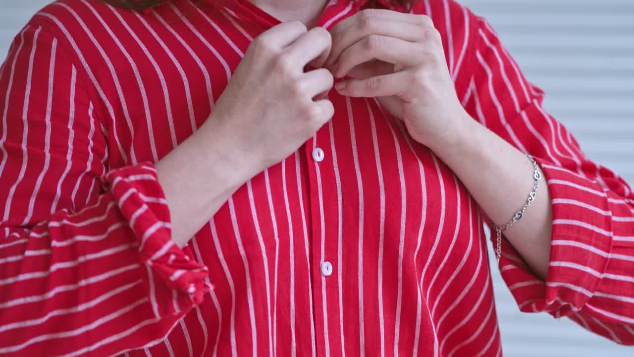 Woman hands buttoning shirt. Stylish woman wearing shirt buttoning button