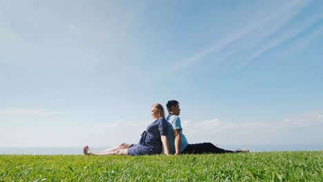 Multi-Ethnic-Couple-Resting-On-The-Green-Grass-Admiring-The-Beautiful-Nature