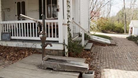 antique water pump on the porch of an old house