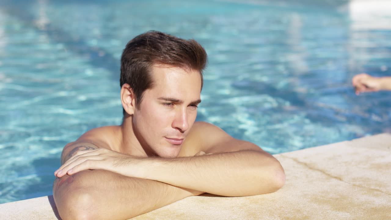 문신을 한 미소 짓는 남자가 여자친구에게 안혀 있다