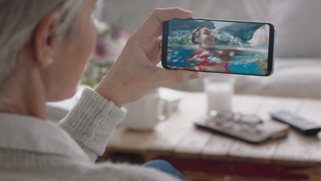 mature-woman-having-video-chat-using-smartphone-waving-at-daughters-swimming-on-vacation-in-italy-sharing-travel-experience-on-mobile-phone-enjoying-connection-chatting-to-grandmother-4k