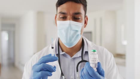 Médico-Varón-Hispano-Preparando-Inyección-Usando-Mascarilla