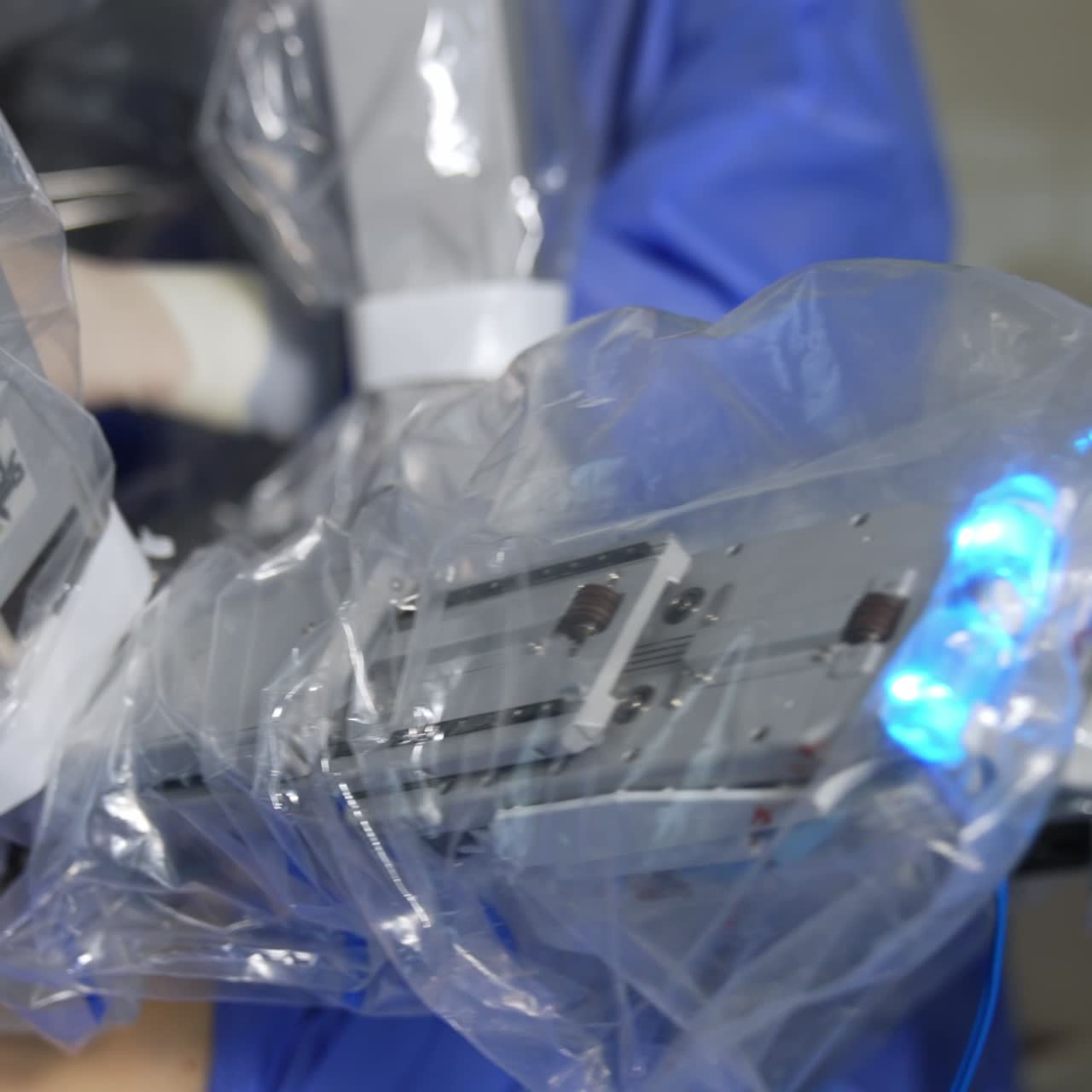 Minimally invasive surgery performed by a robotic equipment. Doctor standing in machine operative field at backdrop in blur