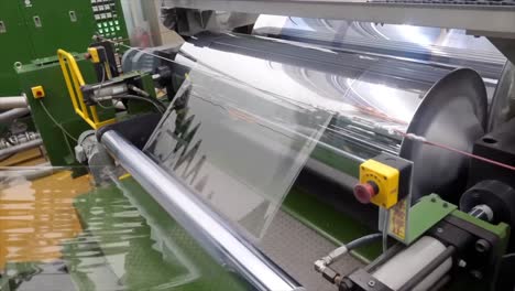 process shapes polyethylene plastic box in plastic manufacturing industry. transparent polyethylene moves through factory reels during this manufacturing process.