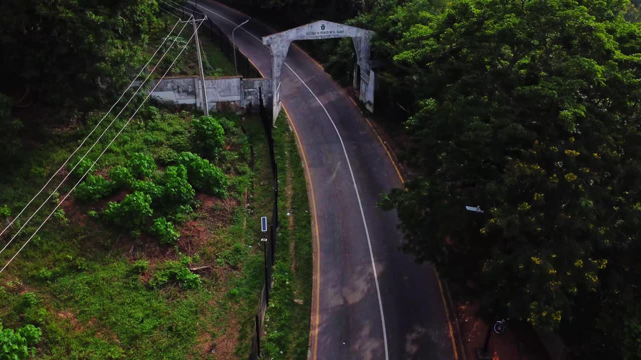 Aerial view of the entrance of the Premier Hotel in Ibadan, Nigeria. Cars drive over the road running through the hills