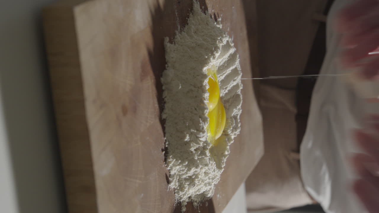 Rompere le uova per la pasta fresca fatta in casa in verticale