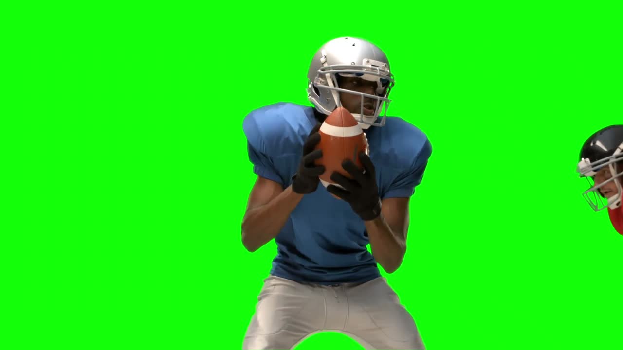 Giocatore di football americano serio che placa per il pallone