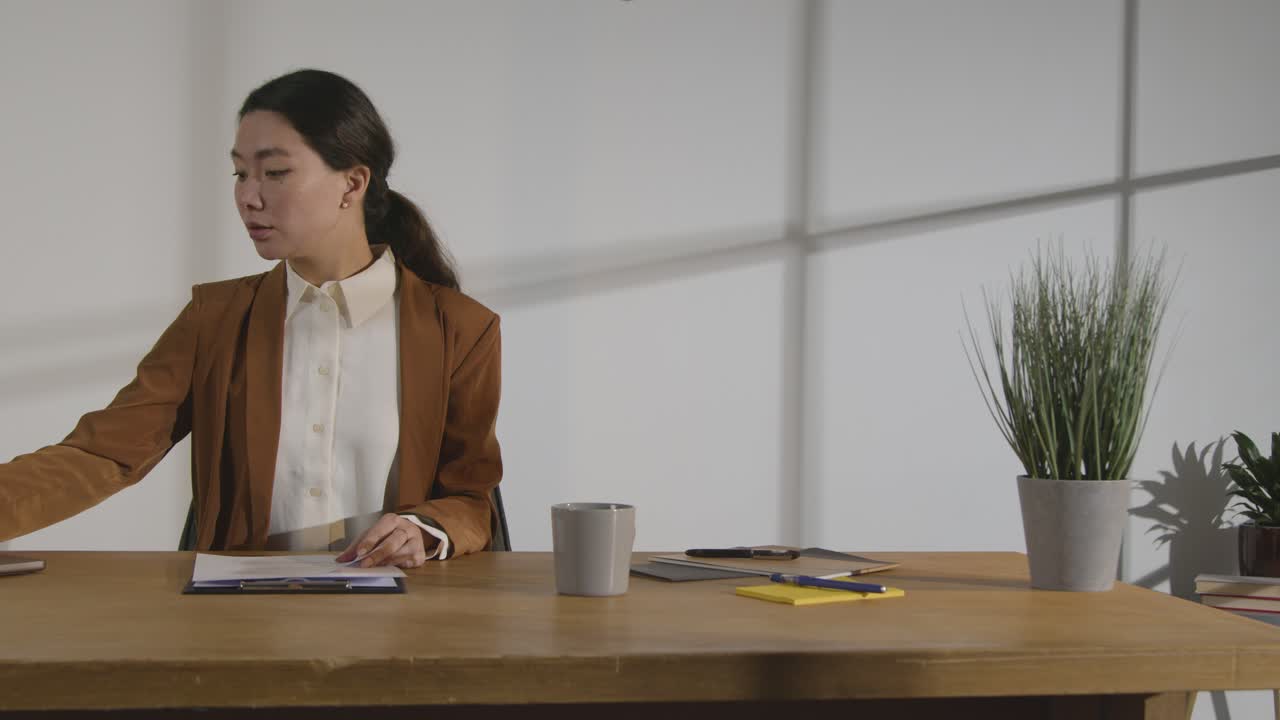 Businesswoman In Office Reviewing And Making Notes On Application Or CV For Job Vacancy 5