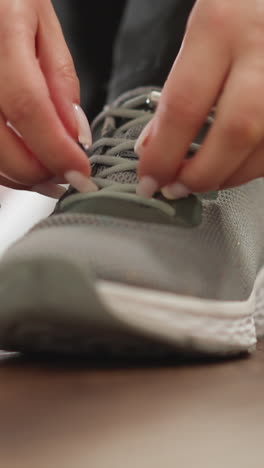mujer aprieta los cordones de las zapatillas de deporte de primer plano. mujer deportiva enérgica se pone zapatos deportivos para correr en el club de fitness en cámara lenta. estilo de vida saludable