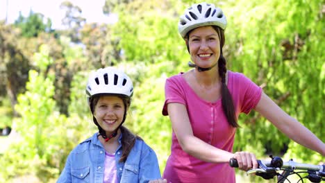 madre e hija en un paseo en bicicleta en el parque juntos