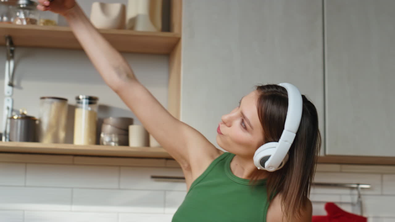 Woman in Headphones Dancing and Taking Selfies in Kitchen