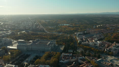 Imágenes-Aéreas-Panorámicas-Del-Histórico-Palacio-Real-Y-Sus-Jardines-Alrededor.-Volar-Sobre-La-Ciudad,-Ver-Contra-El-Sol.