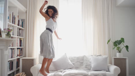 Mujer-Feliz-Bailando-Saltando-En-El-Sofá-Divirtiéndose-Celebrando-Disfrutando-De-Una-Danza-Juguetona-Celebración-Exitosa-Logro-De-Estilo-De-Vida-Femenino-4k