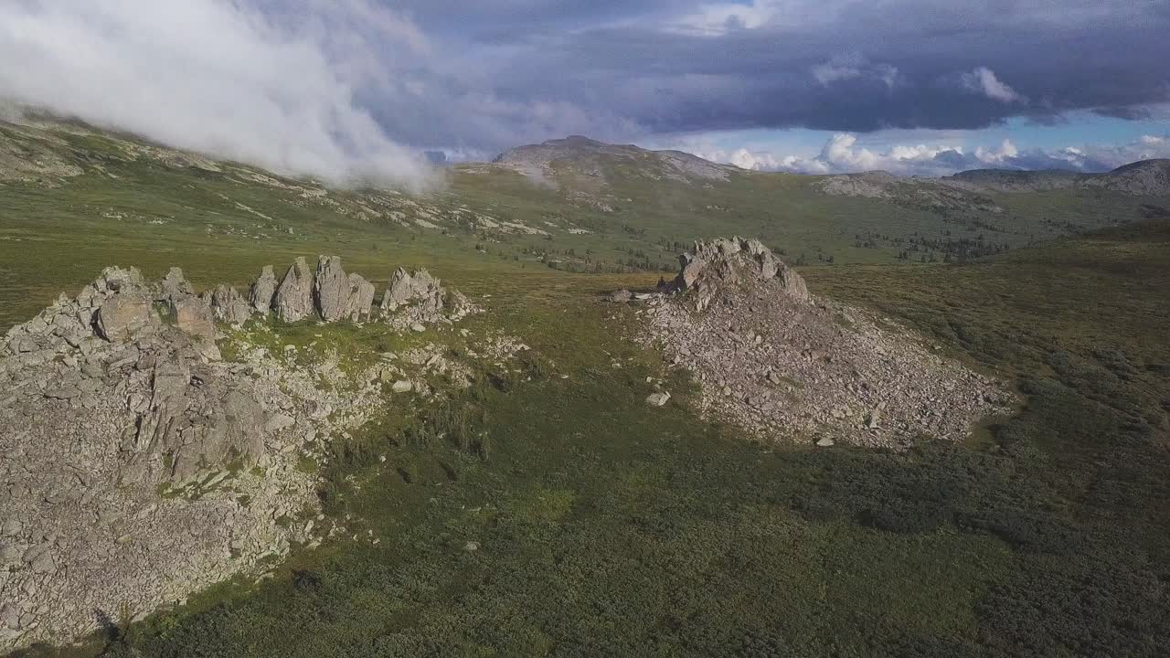 vista aérea de un paisaje montañoso con afloramientos rocosos y nubes