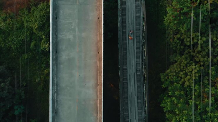 Aerial flight over old and modern bridge with highway above the river