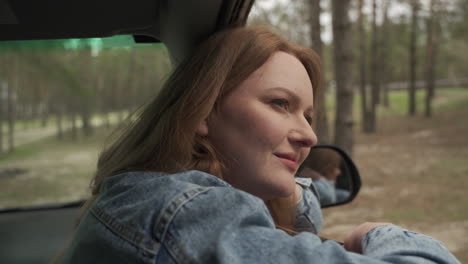 Rothaarige-Frau-Genießt-Eine-Fahrt-Durch-Die-Landschaft-Aus-Dem-Fenster-Des-Autos-3