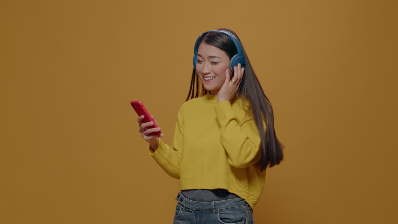 Asian woman listening to music and singing in studio