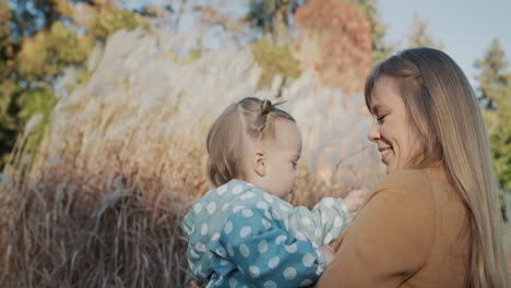 Una-Mujer-Juega-Con-Su-Hija-Y-Le-Muestra-Los-Juncos-En-El-Parque.-Pasar-Un-Buen-Rato-Al-Aire-Libre-En-Un-Día-Claro-De-Otoño