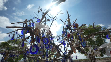 Evil-Eye-Souvenirs-From-Cappadocia-Turkey-Handing-on-Tree,-Close-Up-Slow-Motion