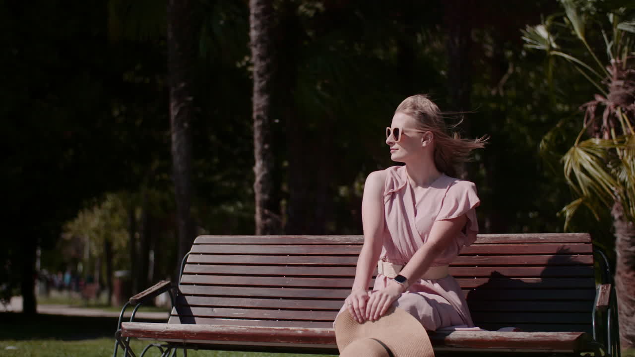 Young Woman Sunbathing in Park with Sunglasses