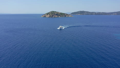 aerial: tourist boat moving quickly across the blue sea