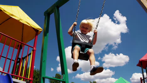 happy child playing on a swing at a playground