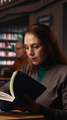 vertical video determined woman writing thesis citations from a specialty book at the library