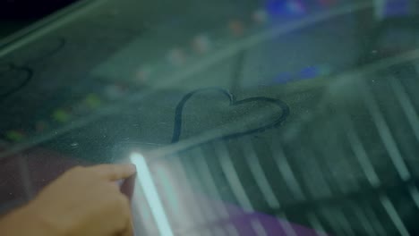 heart drawn on a car window at night