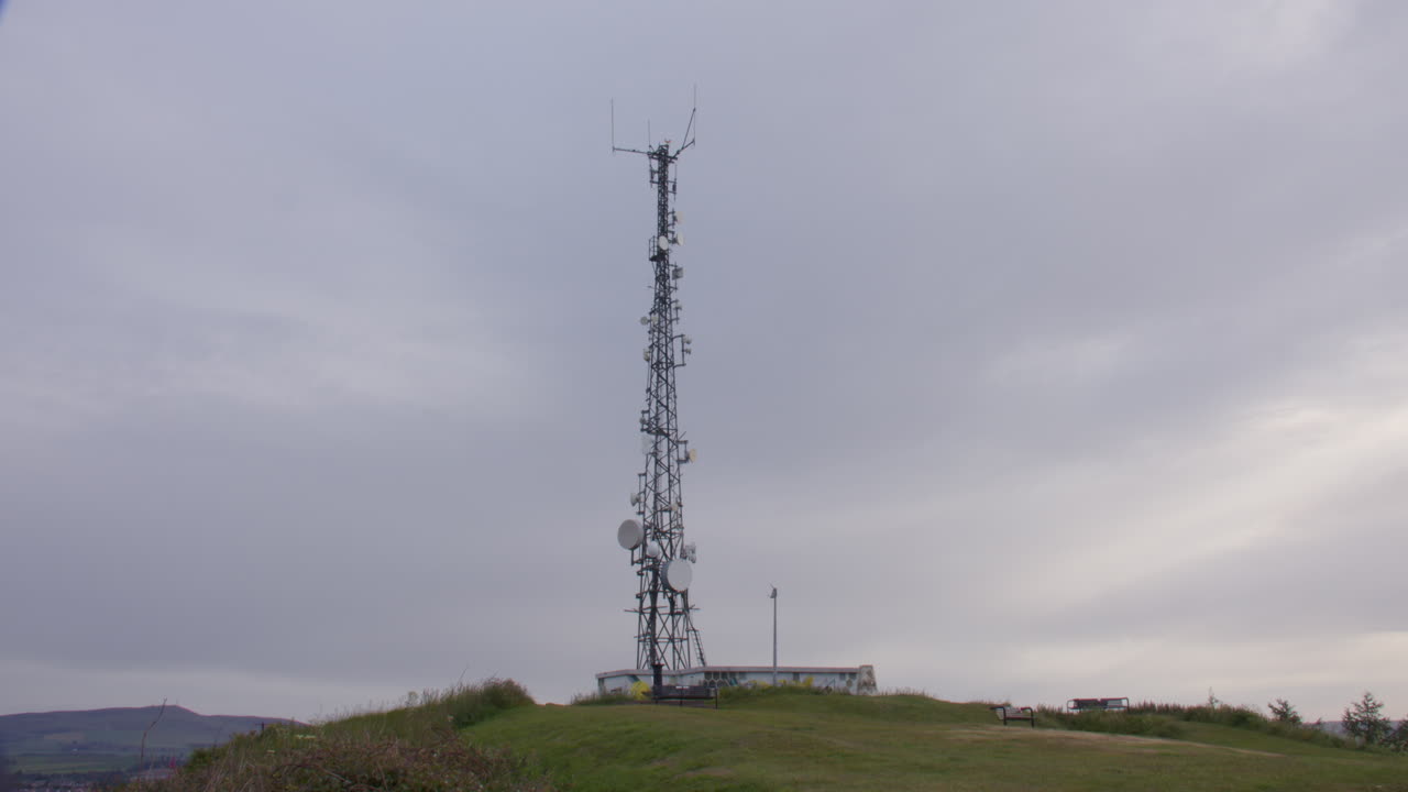 Wide panning shot of Dundee transmitting station mast for radio on top of law hill