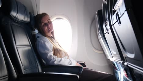 A lone traveler sleeps by the window of an airplane before the exciting journey that lies ahead
