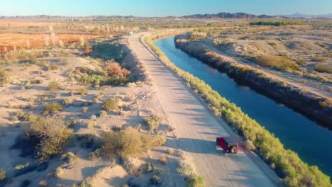 Drohnen-Luftaufnahme,-Die-Dem-Fahrzeug-Folgt,-Das-Entlang-Des-Gila-Schwerkraftkanals-Fährt---Yuma-Arizona