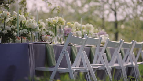 party in blooming garden in springtime served and decorated by flowers table for dinner