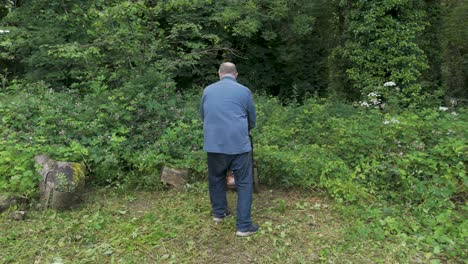 man using a brush cutter to clear overgrown land