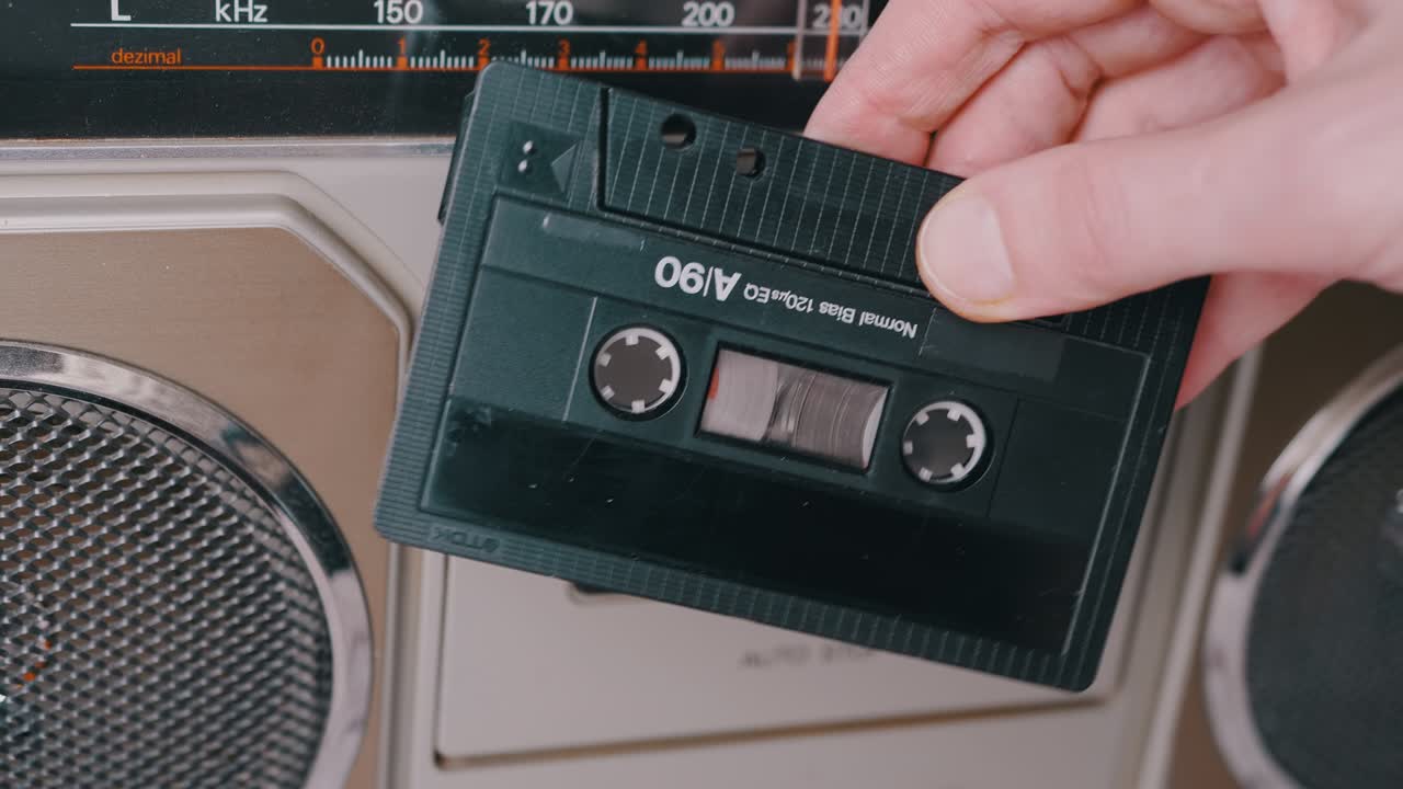여성 손 회전: 스테레오 테이프 레코더 근처의 90년대의 오래된 오디오 카세트