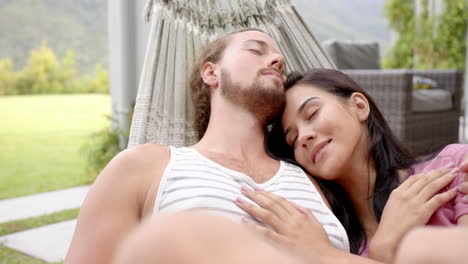 A-young-biracial-couple-relaxes-in-their-serene-backyard